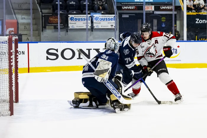 Lars Steiner disputant la rondelle devant le filet de Gladu.