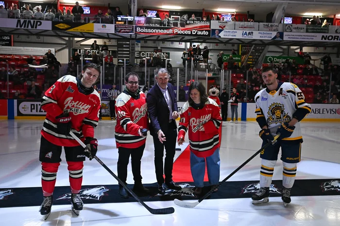 Pierre Turgeon à la mise au jeu protocolaire avec les capitaines de chacune des équipes.